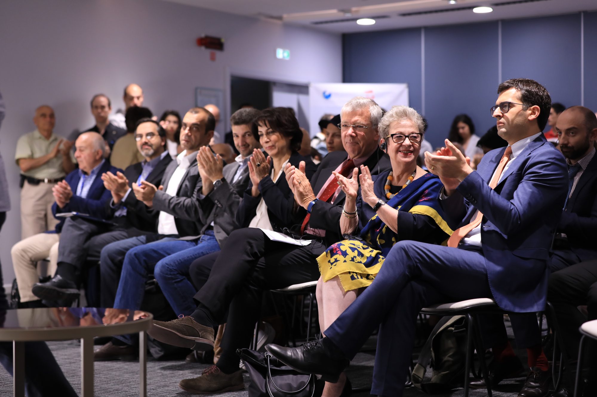 Senior figures applauding in the audience at the Convergence Conference